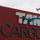 Detalhe da fachada do novo terminal da TAM Cargo em Guarulhos com avião ao fundo